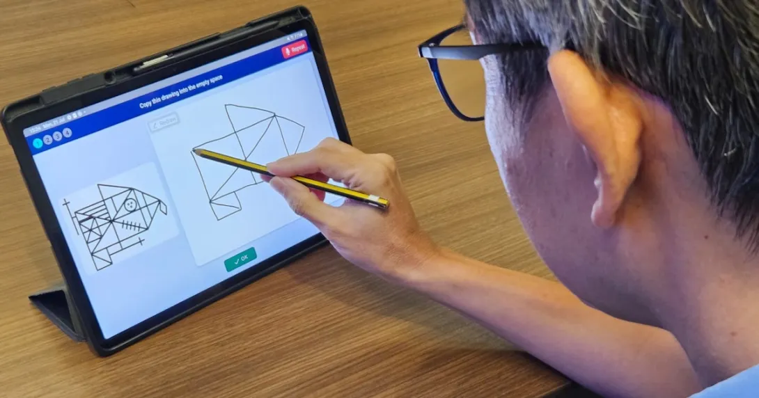 An elderly user takes the pre-dementia drawing test on a digital tablet An elderly user takes the pre-dementia drawing test on a digital tablet